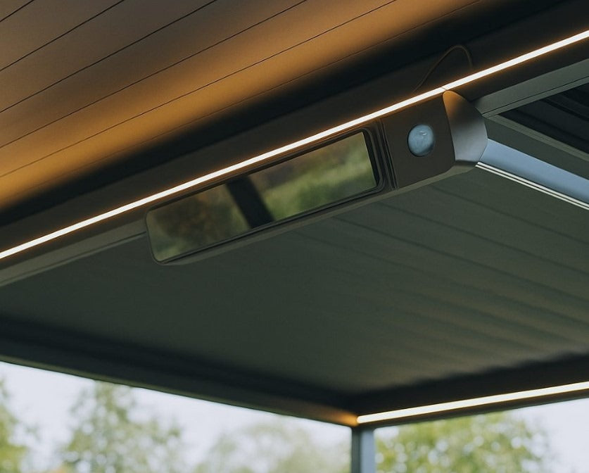 Slim wall-mounted electric heater integrated under a modern aluminium pergola with warm LED lighting – Aluminium Pergola UK.